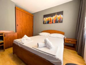 a bedroom with a bed with white pillows on it at GRAND - Beachfront Rooms & Apartments in Selce