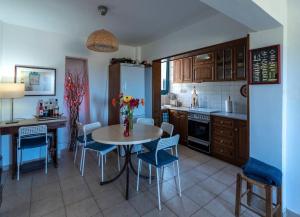 a kitchen with a table and chairs and a kitchen with a refrigerator at Villa Amerita in Elia Laconias