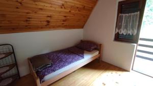 a small bedroom with a bed in a cabin at Apartman Mitrić in Šipovo