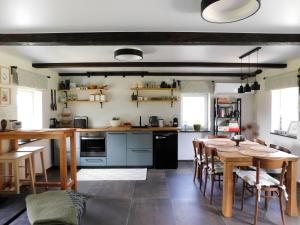 eine Küche mit Tisch und Esszimmer in der Unterkunft Mėta House in Merkinė