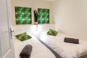 a bedroom with two beds and two paintings on the wall at Mitre's Edge Orchard Suite in Klapmuts