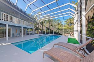 a swimming pool with two chairs and a glass ceiling at Family friendly with large pool in Sarasota