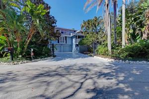 a house with palm trees in front of a driveway at Family friendly with large pool in Sarasota