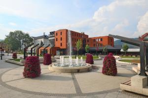 einen Brunnen auf einem Platz vor einem Gebäude in der Unterkunft Zepter Hotel Drina Bajina Basta, member of Zepter Hotels in Bajina Bašta