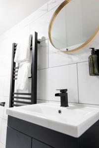 W łazience znajduje się biała umywalka i lustro. w obiekcie Chic Urban 2 Bedroom Apartments w Cardiff