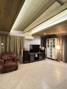 a living room with a couch and a television at Magic View 4U Luxury Villa, Tago Vibes in Kineta