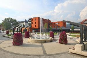 einen Brunnen auf einem Platz vor einem Gebäude in der Unterkunft Zepter Hotel Drina Bajina Basta, member of Zepter Hotels in Bajina Bašta