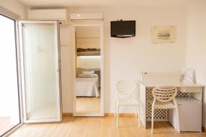 a room with a mirror and a table and chairs at Hotel Playa in Peñíscola