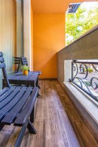 a porch with a wooden bench and a balcony at Style and luxury 10mins Center in Plovdiv