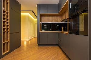 a kitchen with black cabinets and a wooden floor at Style and luxury 10mins Center in Plovdiv