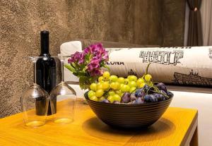 a bowl of grapes and a bottle of wine on a table at Style and luxury 10mins Center in Plovdiv