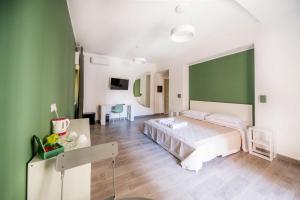 ein Schlafzimmer mit einem Bett und einer grünen Wand in der Unterkunft Akheilos in Soverato Marina