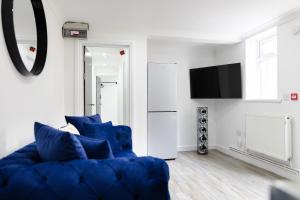 Chic Urban 2 Bedroom Apartments في كارديف: غرفة معيشة مع أريكة زرقاء وتلفزيون