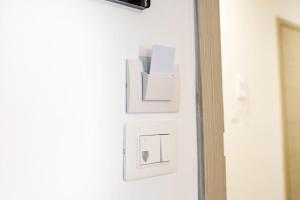 a white lightswitch on a wall next to a door at Akheilos in Soverato Marina
