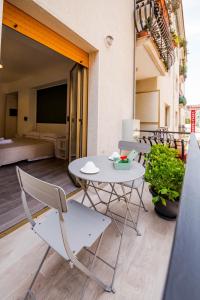 einen Tisch und Stühle auf einem Balkon mit einem Schlafzimmer in der Unterkunft Akheilos in Soverato Marina