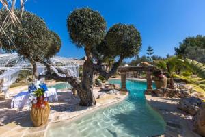 a swimming pool with trees in a resort at Villa Tiziana in Castrignano del Capo