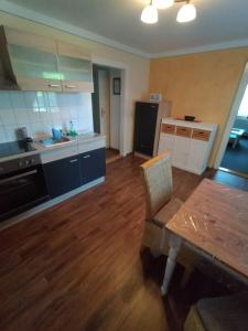 eine Küche mit Holzboden und einem Tisch in einem Zimmer in der Unterkunft Ferienwohnung 3 Am Zahnsborn in Bad Schandau