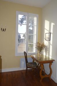 einen Tisch und einen Stuhl in einem Zimmer mit Fenster in der Unterkunft Château Nardon Crimon in Saint-Christophe-des-Bardes