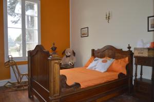 a bedroom with a bed with a teddy bear sitting next to it at Château Nardon Crimon in Saint-Christophe-des-Bardes