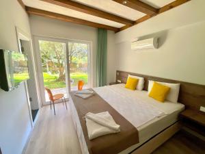 a bedroom with a bed with yellow pillows and a window at Güneş Boutique Hotel - Oludeniz in Oludeniz +241 photos