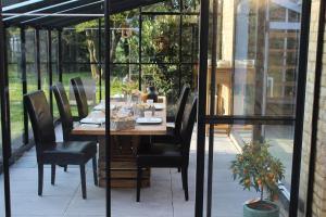 Une table et des chaises en bois sont disponibles sur la terrasse. dans l'établissement B&B L’Orangerie, à Lo-Reninge