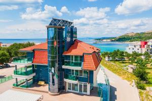 a building with a clock tower next to the ocean at Villa Viktor in Topola