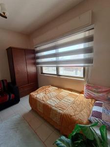 a bedroom with a bed and a window with a blind at شقة RIMA in Al Salt