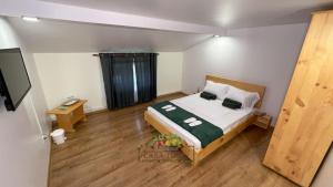 a small bedroom with a bed and a television at Casa Tudor in Târgu Ocna +35 photos