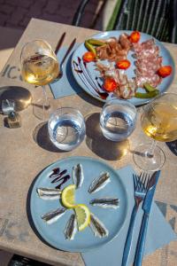a table with plates of food and glasses of wine at ibis Styles Aubagne Gemenos in Gémenos