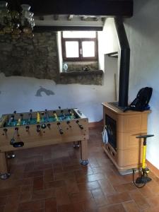 mesa de ping pong en una habitación con estufa de leña en Casa nell'arco, en Bagni di Lucca