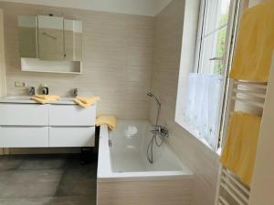 ein Bad mit einer Badewanne, einem Waschbecken und einer Dusche in der Unterkunft Entzückende kleine Vorstadtvilla in Klosterneuburg