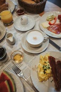 a table with plates of breakfast food on it at HENRI Country House Kitzbühel in Kitzbühel