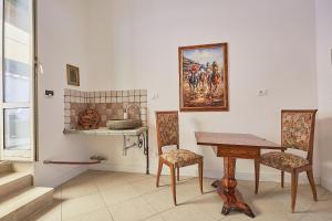 ブラッチャーノにあるLE CAMERE di VITTORIAのテーブルと椅子、壁画が備わるお部屋