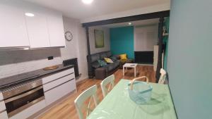 een keuken en een woonkamer met een groene tafel en stoelen bij Zona tranquila, cerca del Casco Antiguo. EBI02480 in Bilbao