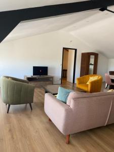 a living room with a couch and two chairs at Polderzicht in Castricum