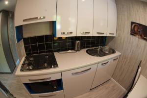 a small kitchen with white cabinets and a stove at The Center Apartments Krakowska in Rzeszów