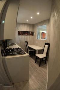 a kitchen with a stove and a table with chairs at The Center Apartments Krakowska in Rzeszów