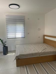 een slaapkamer met een bed en een raam bij במורד ההר in Shelomi