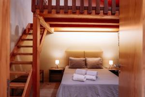 a bedroom with a loft bed with two white towels at Casa do avô tamanqueiro in Arco de Baúlhe