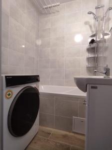 a bathroom with a washing machine and a sink at Apartament Mazury in Kętrzyn