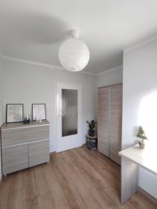 a living room with white walls and a wooden floor at Apartament Mazury in Kętrzyn