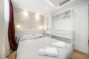 a bedroom with a white bed with two towels on it at Cannes Centre - 10mn Palais, Plages, Croisette - AT in Cannes