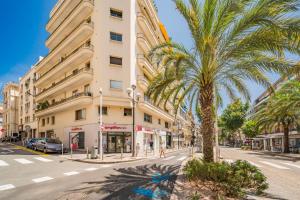 a palm tree on a street in front of a building at Cannes Centre - 10mn Palais, Plages, Croisette - AT in Cannes