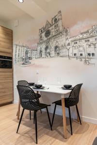 a dining room with a table and chairs with a drawing on the wall at Croix Paquet - Appartements à Lyon in Lyon