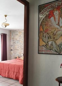 a bedroom with a poster on the wall and a bed at Les GARGOUILLES Gorges du Tarn - Millau in Boyne
