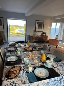 een lange tafel met eten in de woonkamer bij Kerloulou in Poullan-sur-Mer