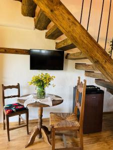 a dining room with a table and chairs and a tv at Inside, The Village- Wooden Hideaway 