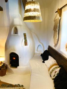 Habitación con cama con chimenea y lámpara de araña. en Inside, The Village- Wooden Hideaway, 