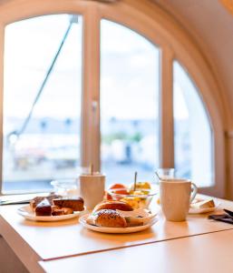 stół z talerzami jedzenia i kubkami kawy w obiekcie Hôtel Du Golfe w Ajaccio
