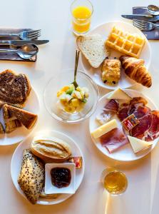 une table blanche avec des assiettes de produits pour le petit-déjeuner dans l'établissement Hôtel Du Golfe, à Ajaccio